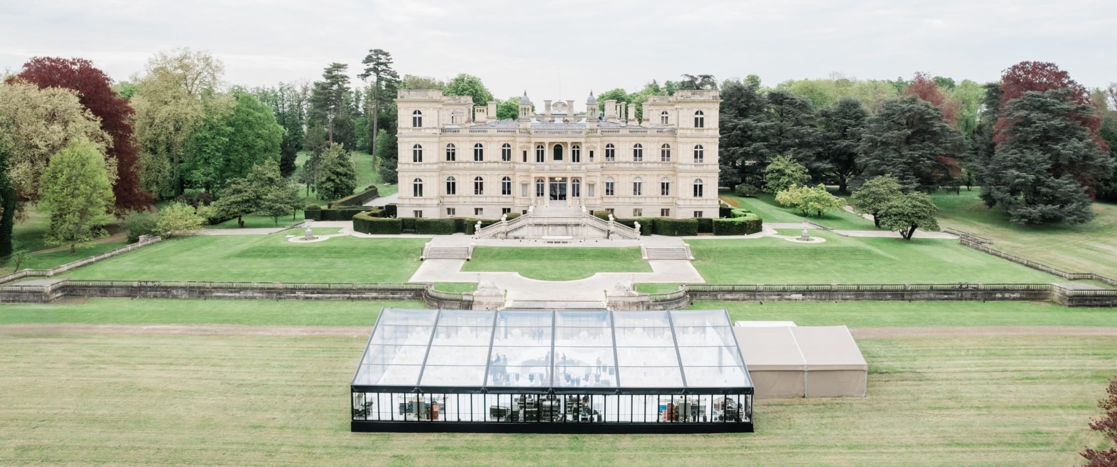 Crystal tent dinner for a Wedding at Château de Ferrières, surrounded by gardens.
